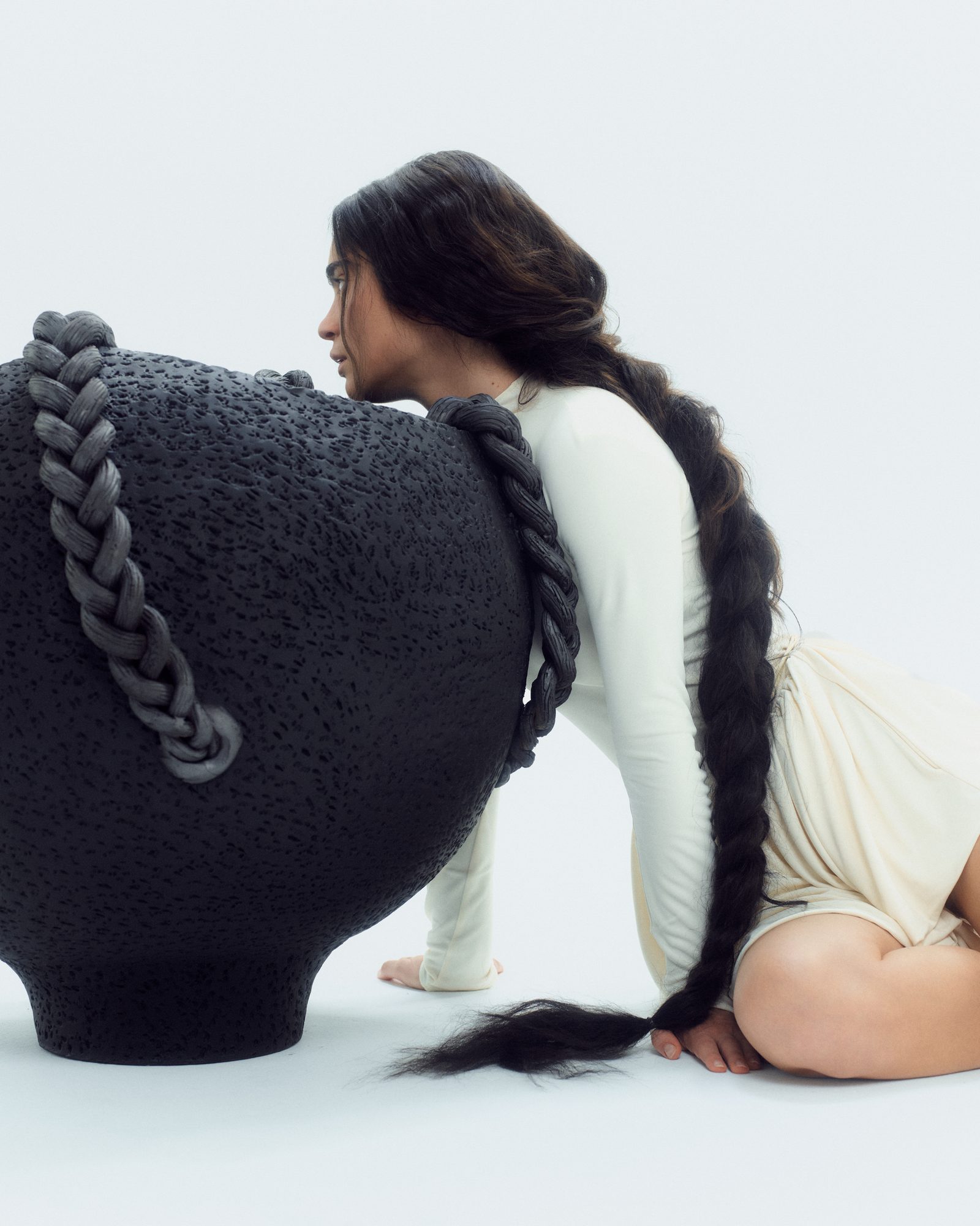 The ceramic vessel — braided iron handles meeting human form